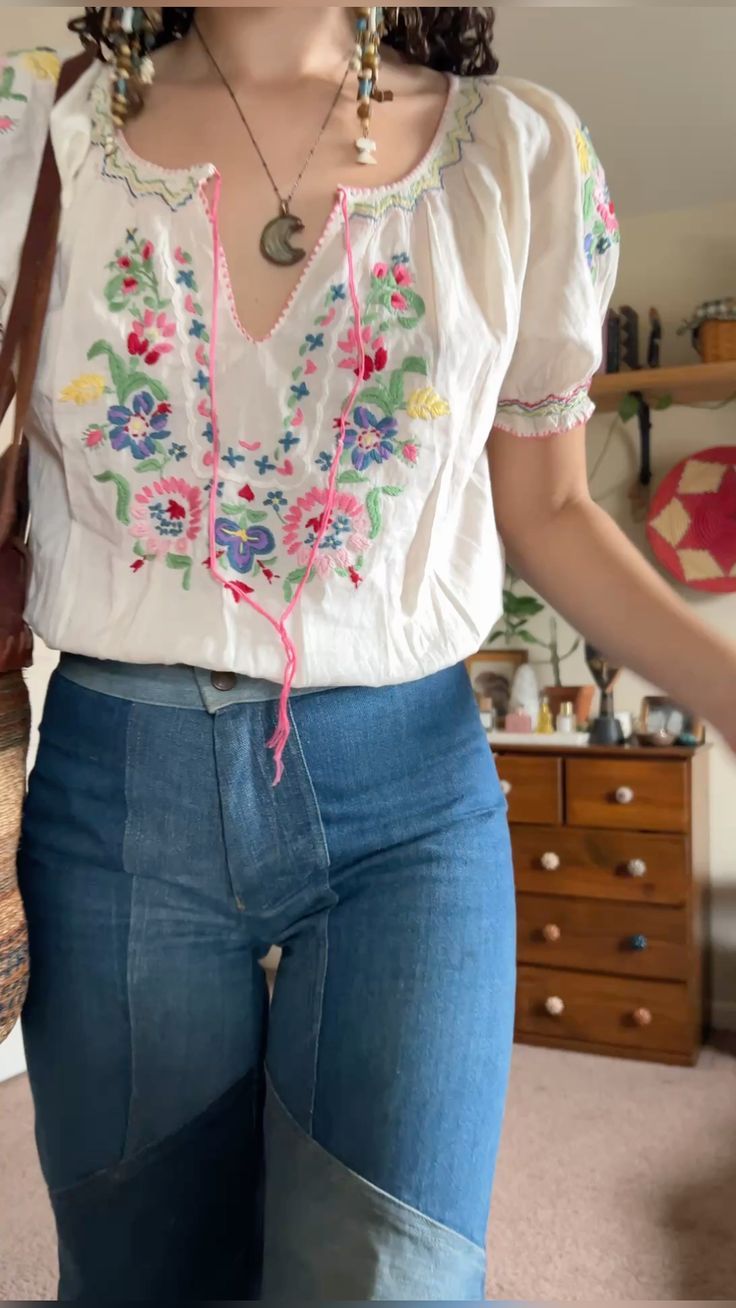Blusa blanca de flores bordadas combinada con mezclilla
