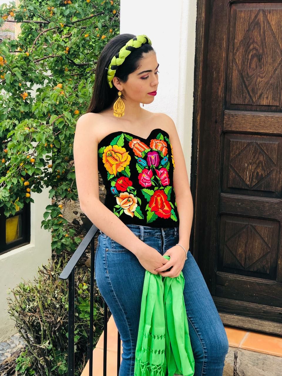 Modelo con corsé negro de flores y pantalón de mezclilla