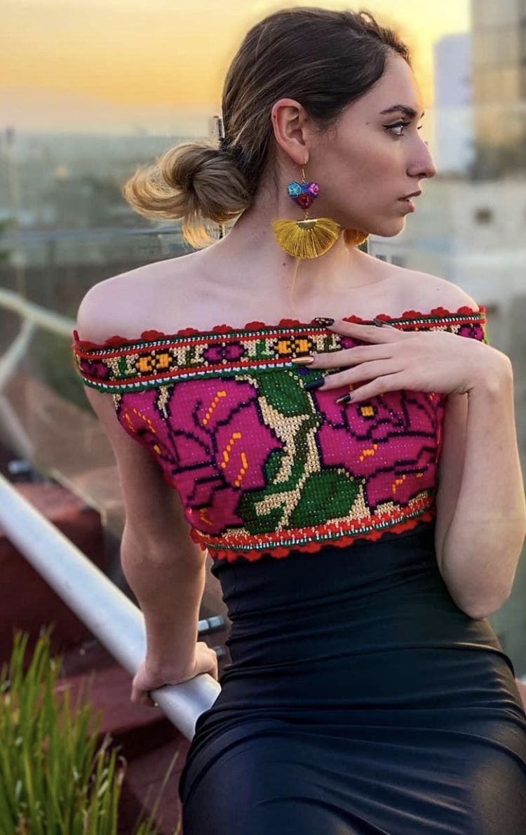 Modelo con top rosa bordado y falda negra
